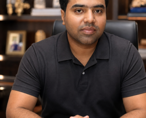 Syed Raheel Shahzad — Black Polo Office Portrait Syed Raheel Shahzad (سيد راحيل شهزاد) seated in a black polo shirt at an office desk