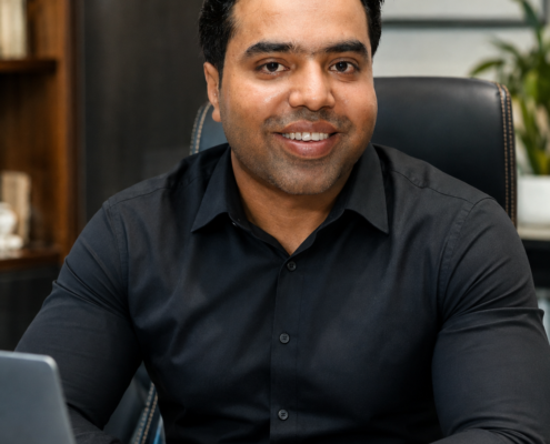 Syed Raheel Shahzad — Executive Office Portrait Syed Raheel Shahzad (سيد راحيل شهزاد) seated in a black shirt in an executive office